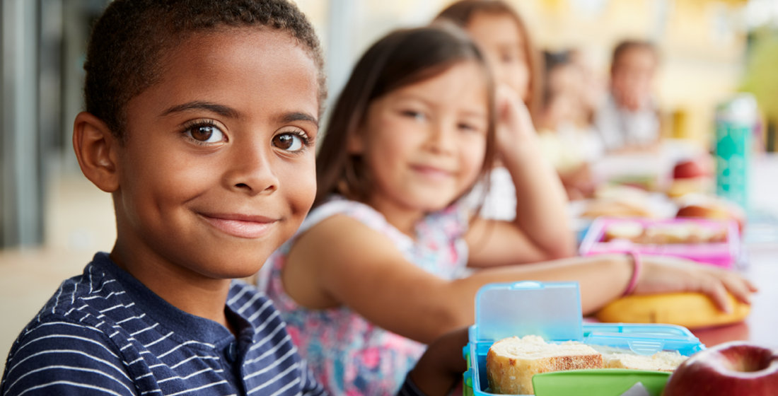 Kinderen met lunchbox met boterhammen erin