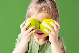 Kind houdt appels voor haar gezicht