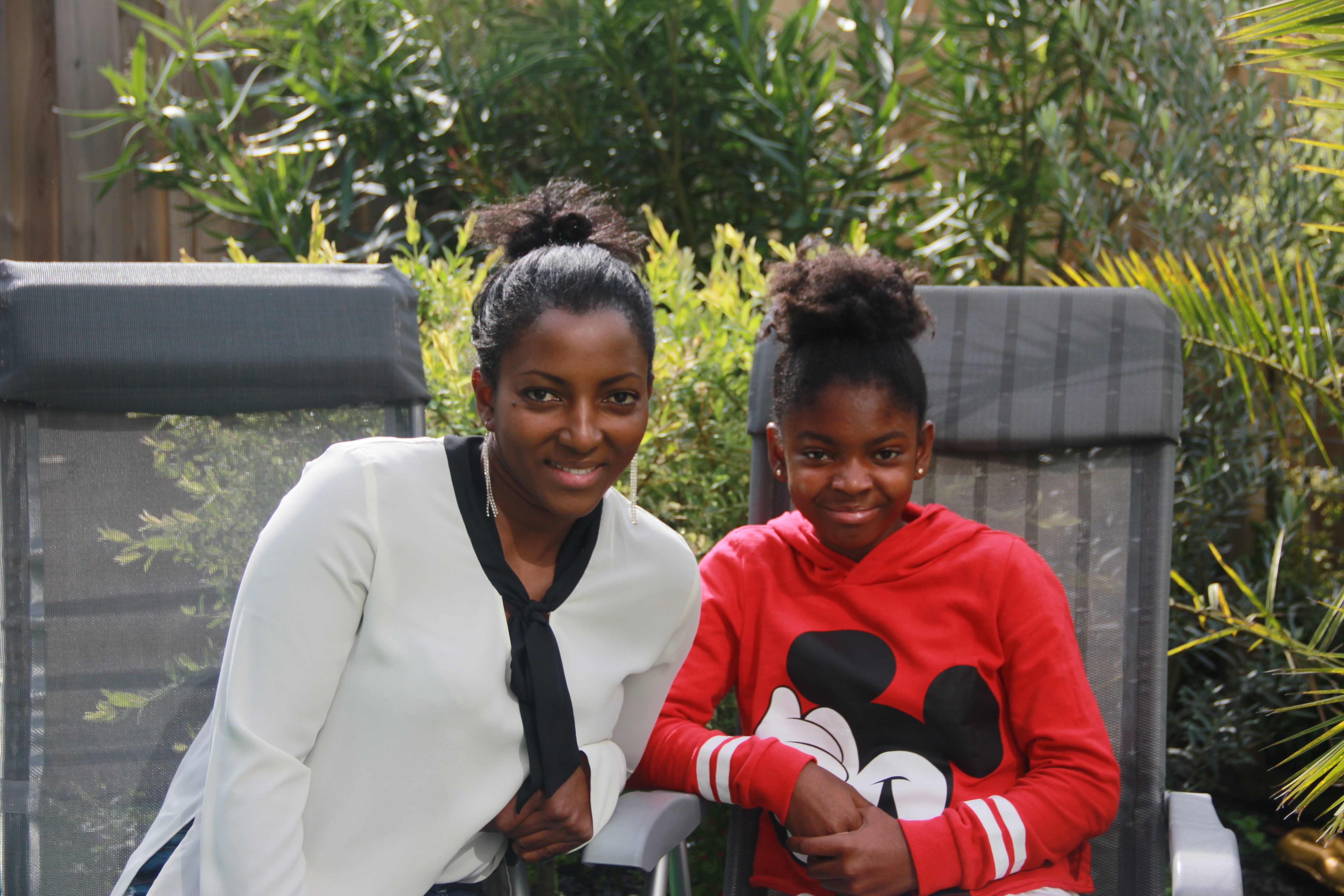 Moeder en dochter zitten samen op stoelen in de tuin