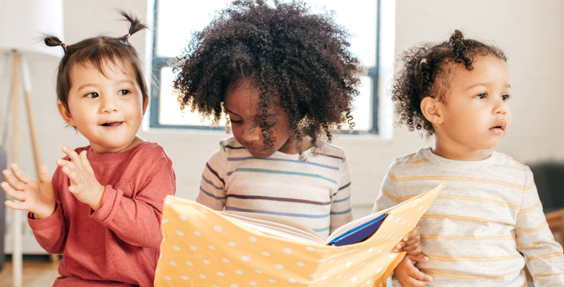 3 kinderen die in een boek kijken