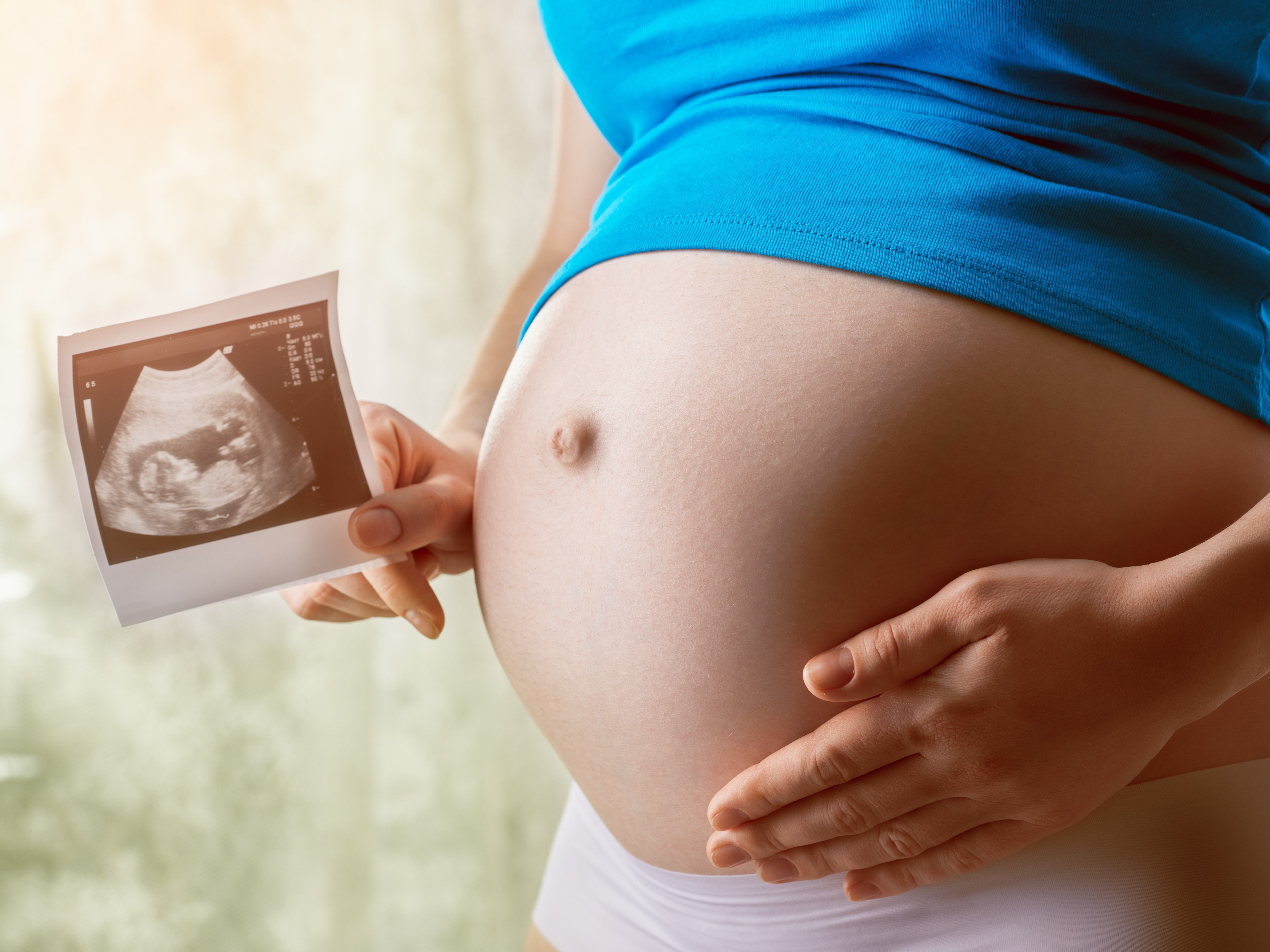 Zwangere met echo foto in haar hand