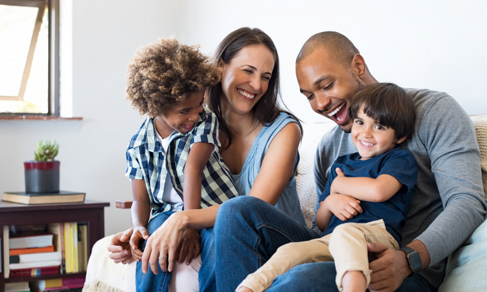 Gezin die op de bank samen zitten en lachen