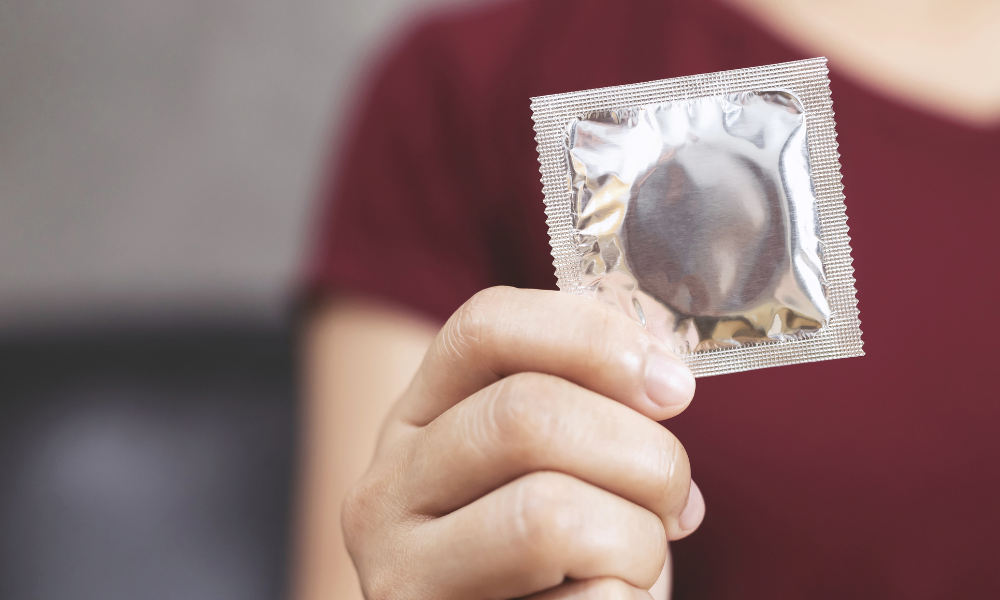 Persoon met condoom in de hand