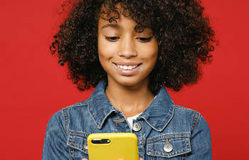 Jongedame kijkt lachend op haar smartphone