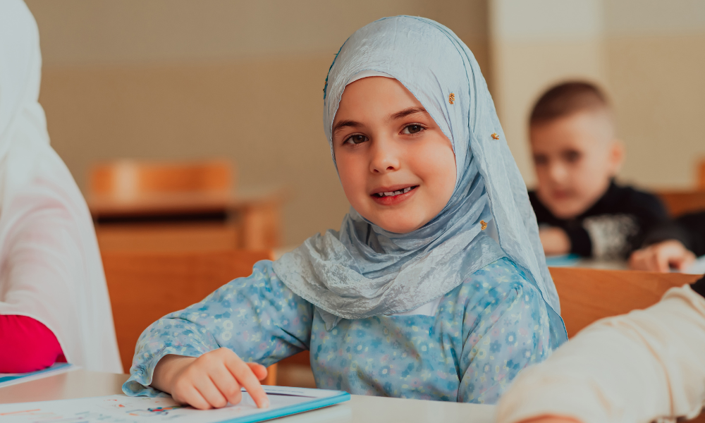 Meisje met hoofddoek zit in de schoolbanken