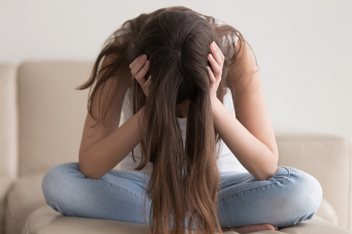 Meisje zit met handen in haar haar