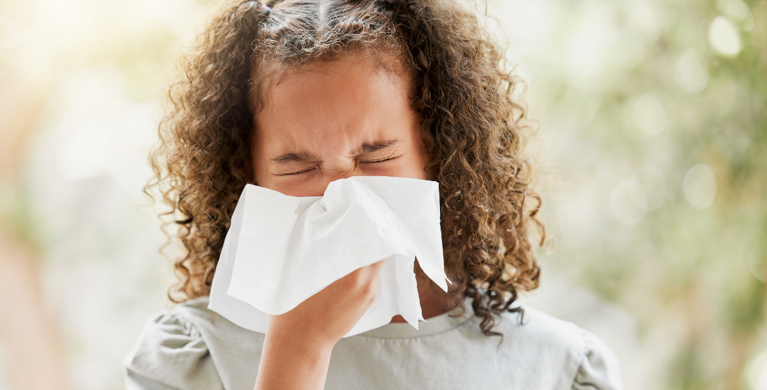 Meisje die niest in een zakdoek