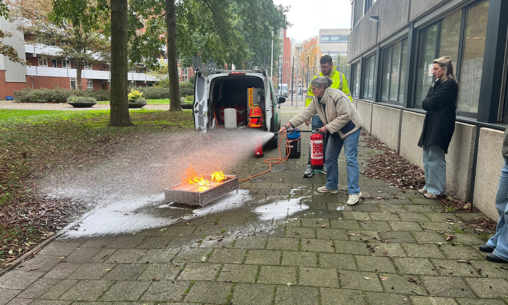 Persoon die brand blust tijdens een BHV-cursus