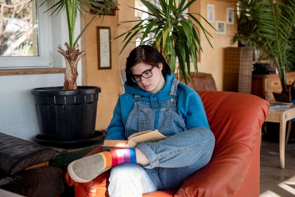 Meisje met tuinpak aan leest boek