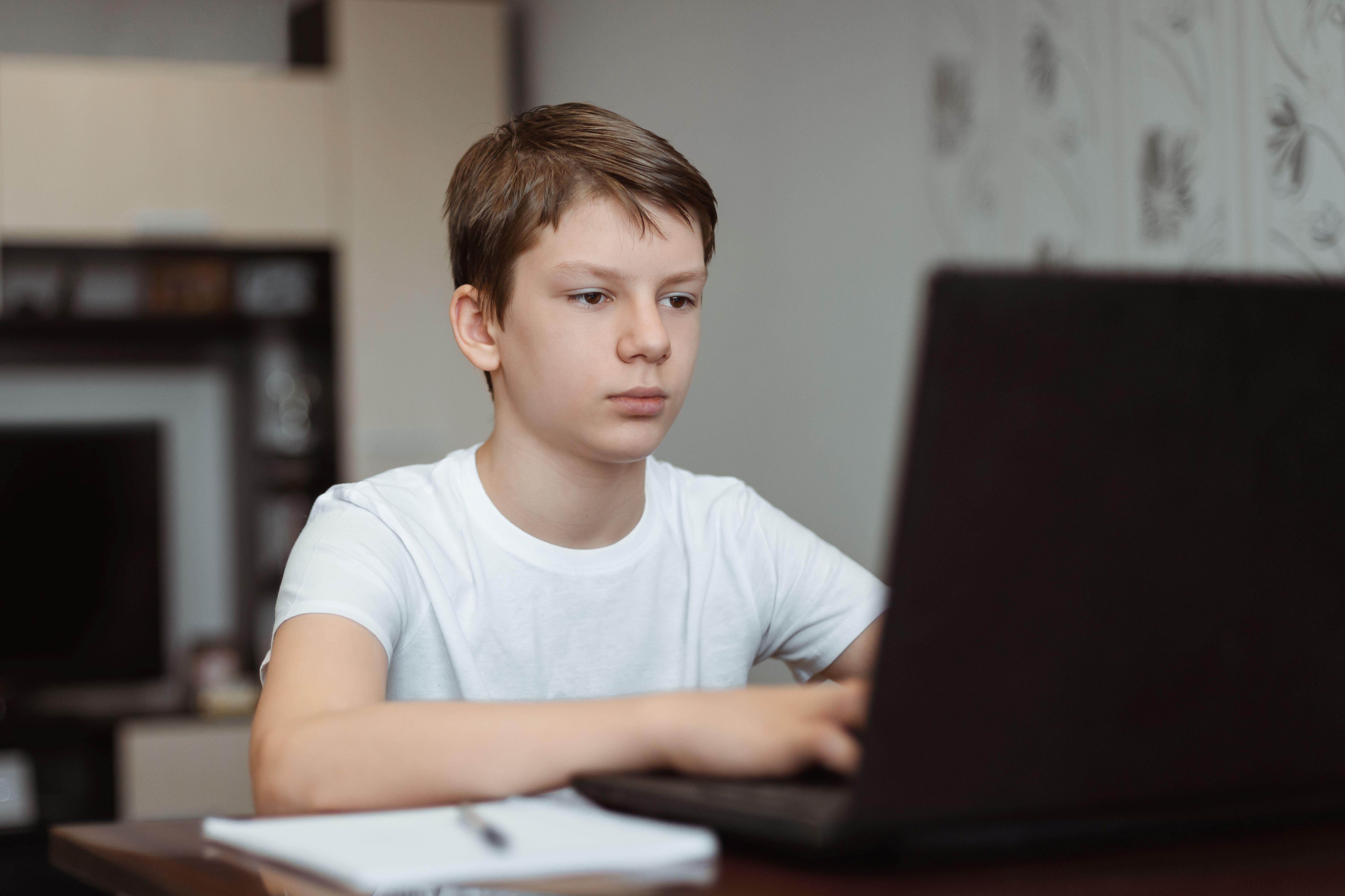 Jongen typt op laptop