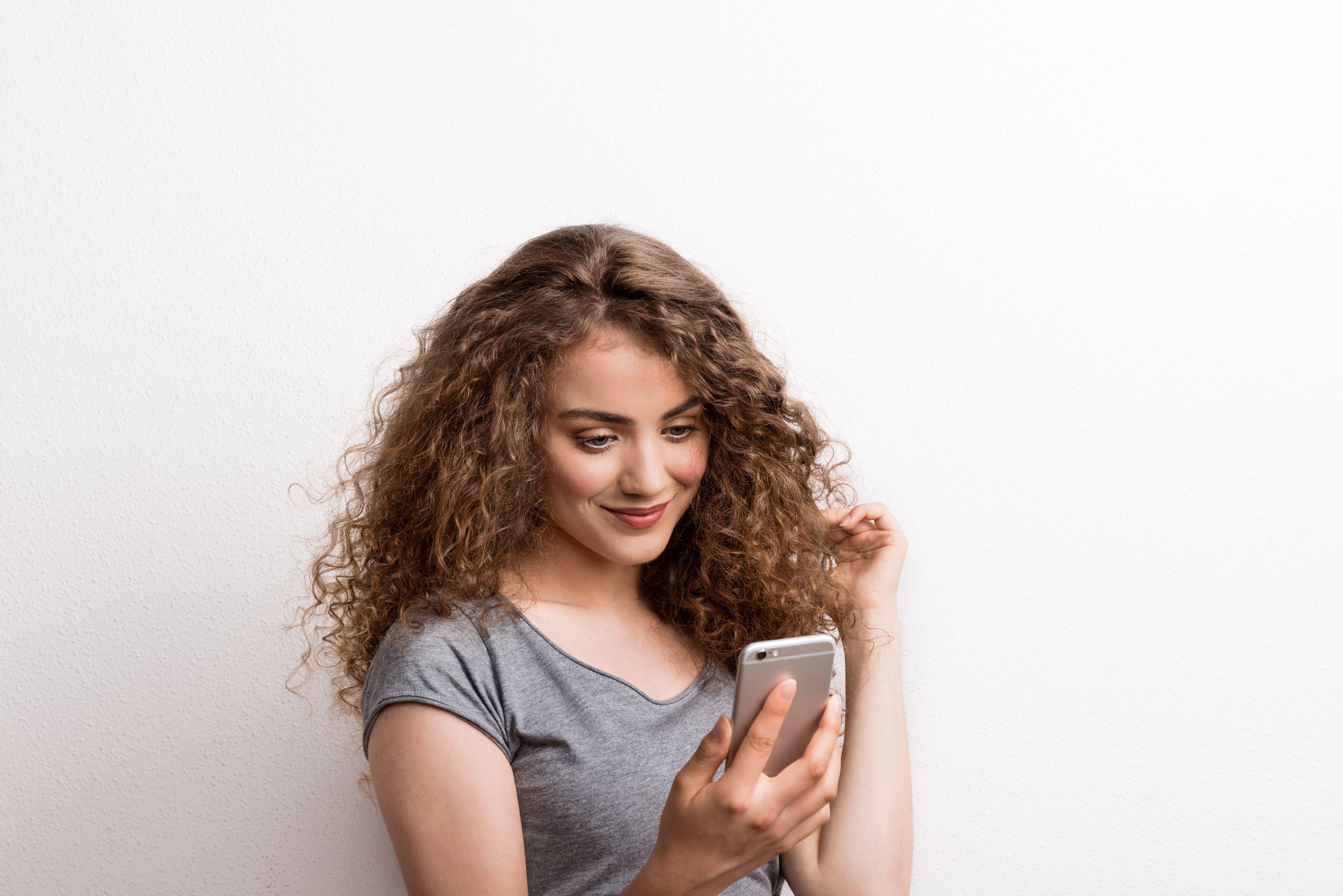 Meisje kijkt verliefd naar haar telefoonscherm