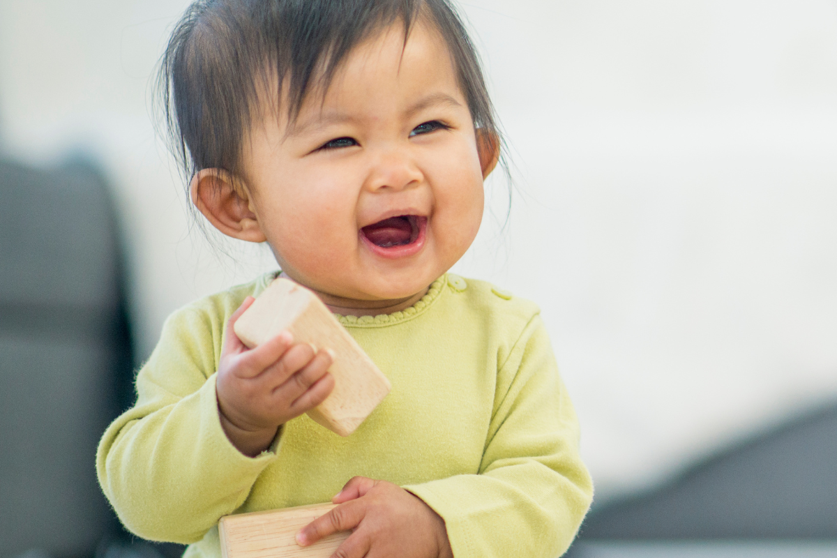 Vrolijke dreumes speelt met houten blokjes