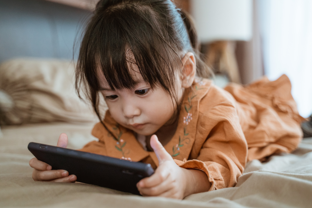 Peuter meisje kijkt op mobiele telefoon