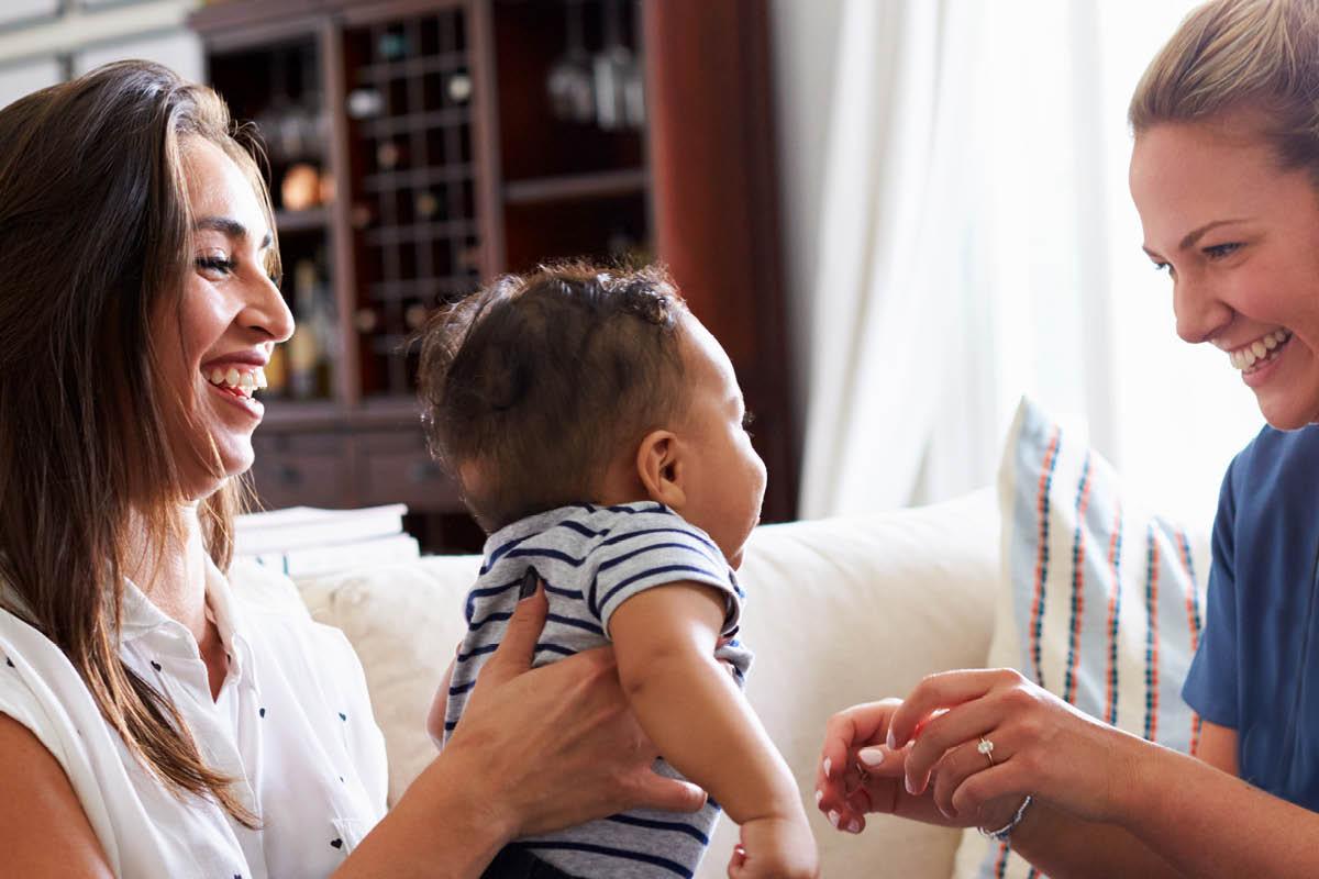 Twee vrouwen spelen met baby