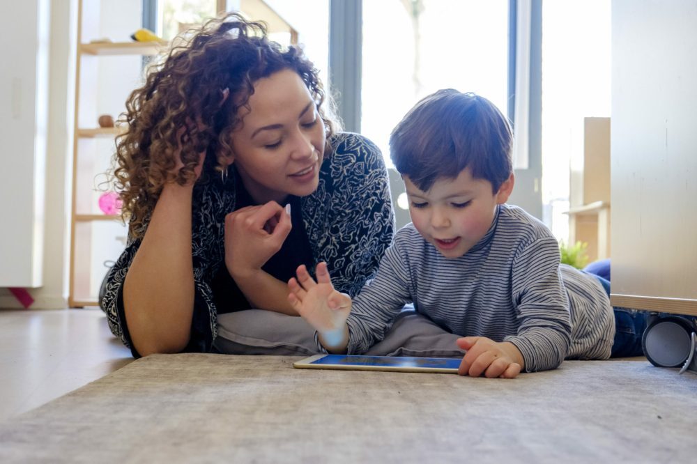 Moeder en zoon kijken samen naar tablet