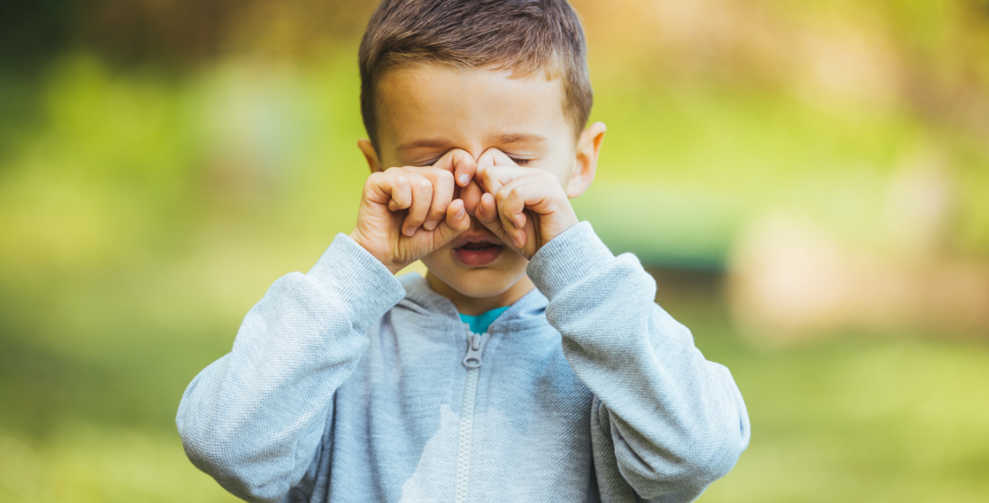 Jongen die in zijn ogen wrijft