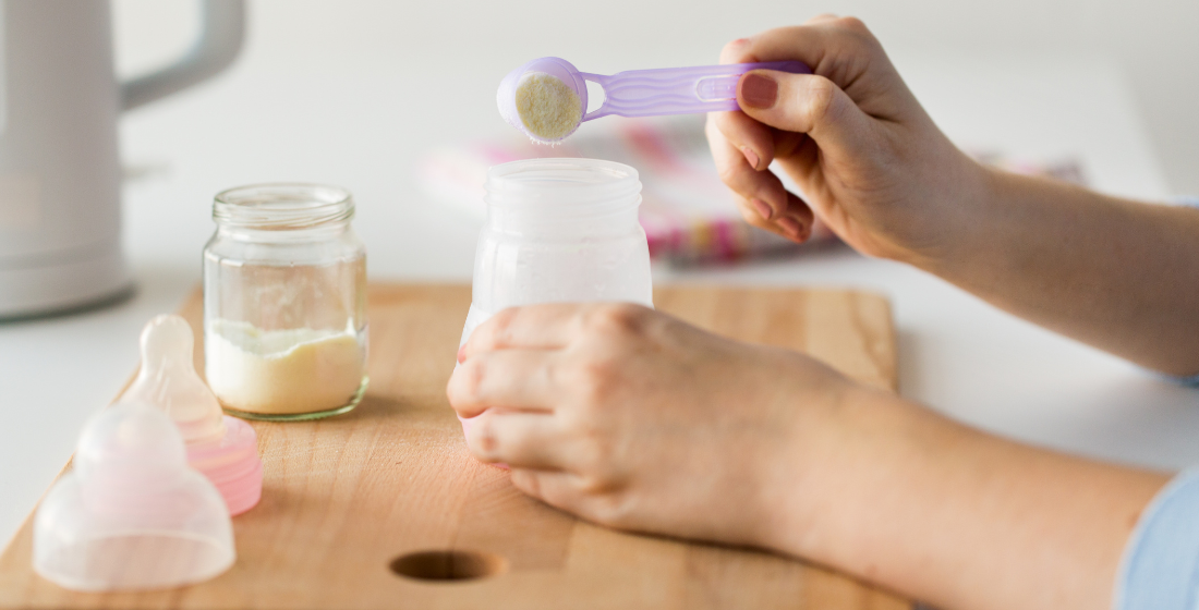 Persoon die flesvoeding klaarmaakt