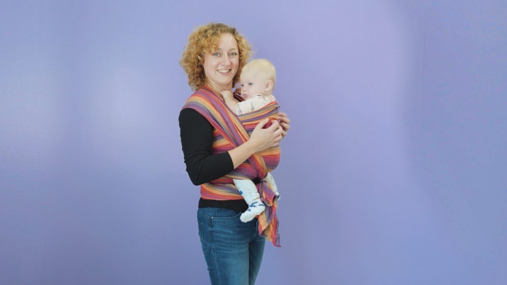 Moeder die baby in geweven draagdoek draagt