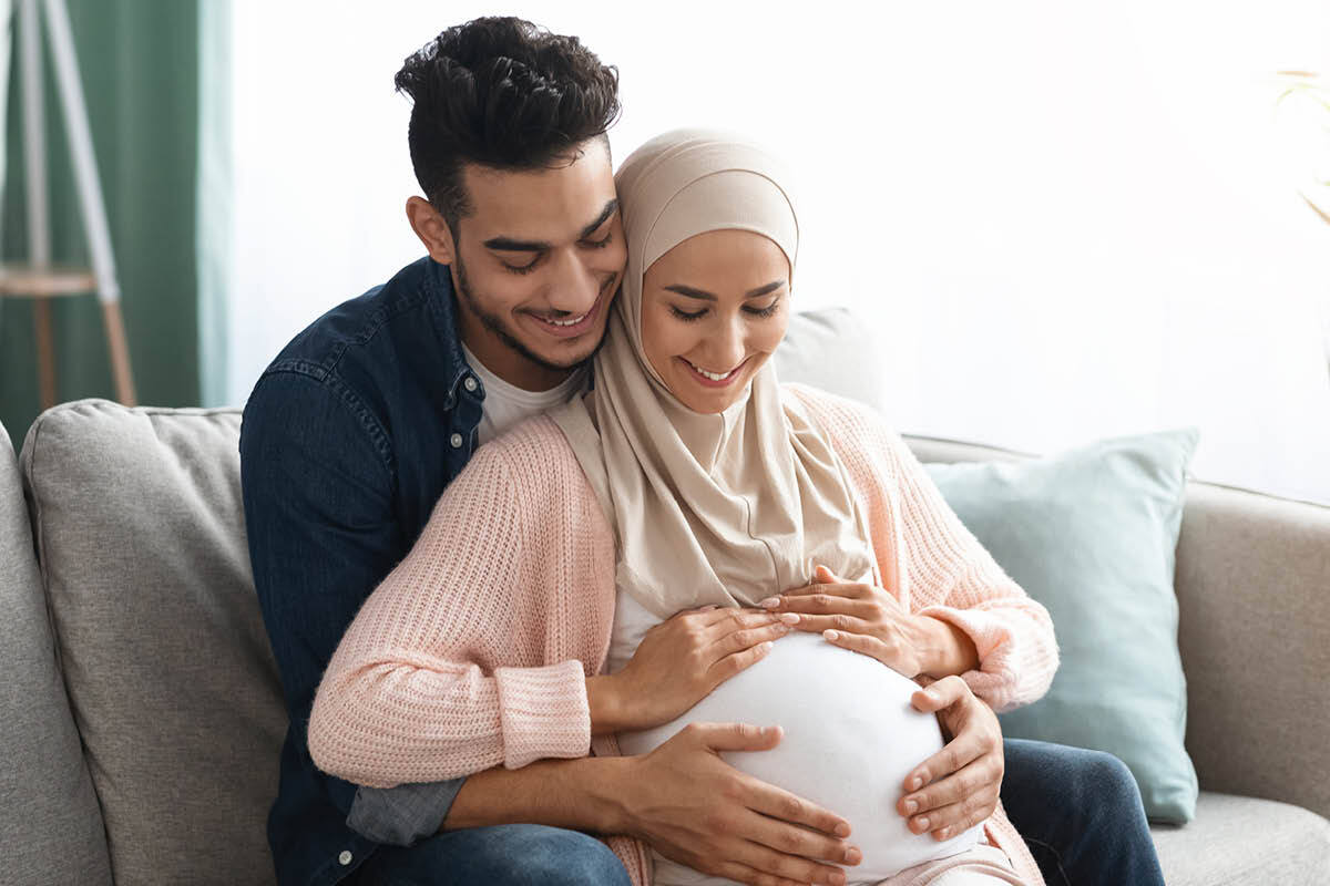 Zwangere vrouw en partner die glimlachen naar haar buik