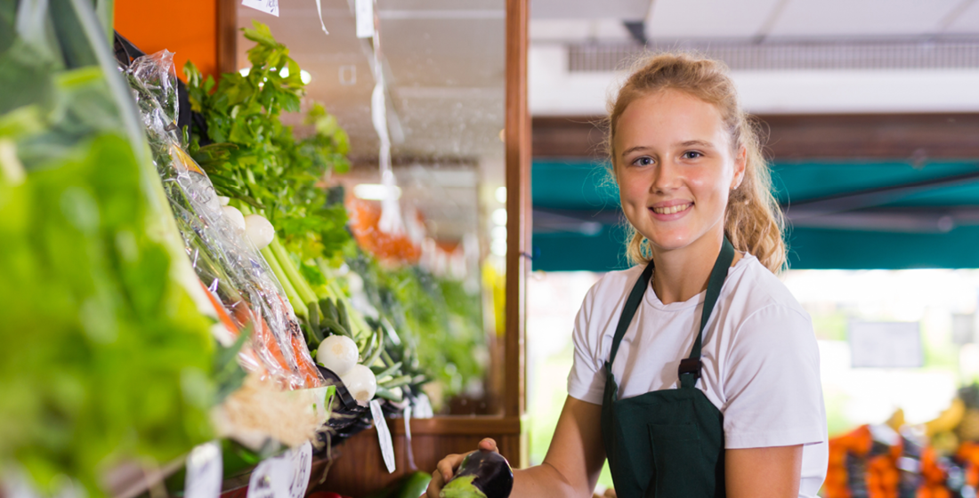 Puber meisje werkt bij groentenkraam