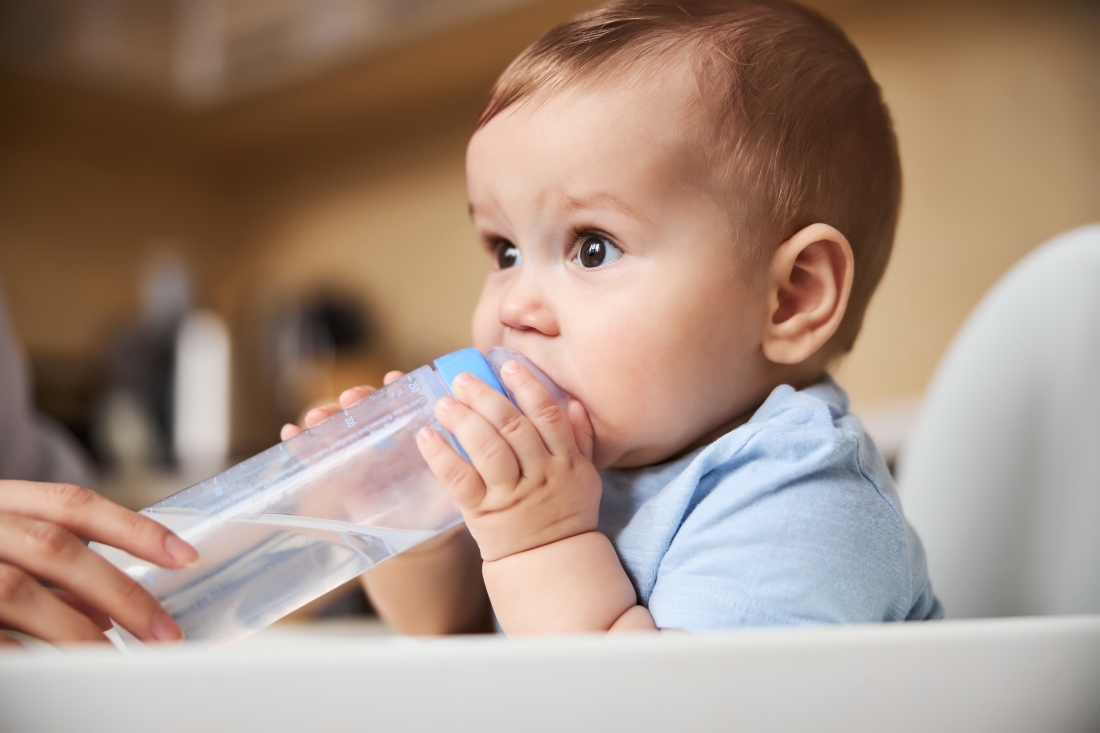 Baby die aan het drinken is uit de fles