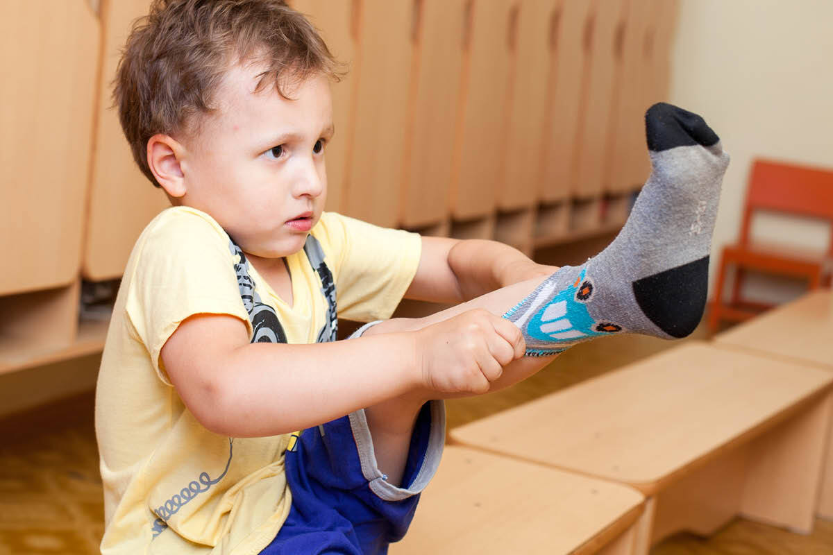 Kleuter die zijn sok aantrekt