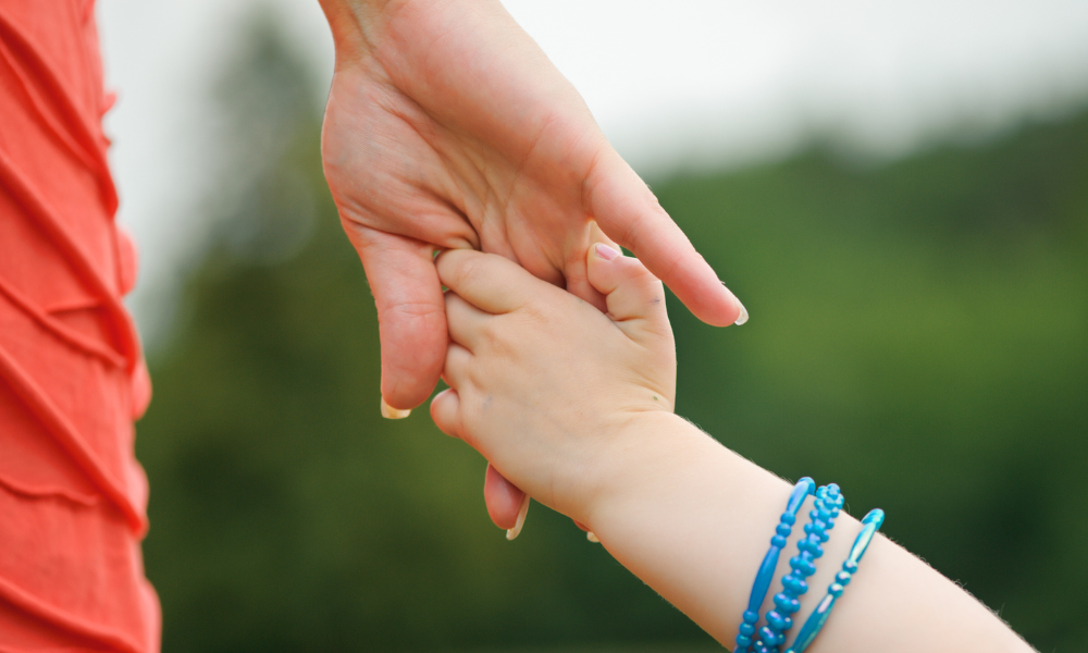 Ouder en kind die elkaars hand vasthouden