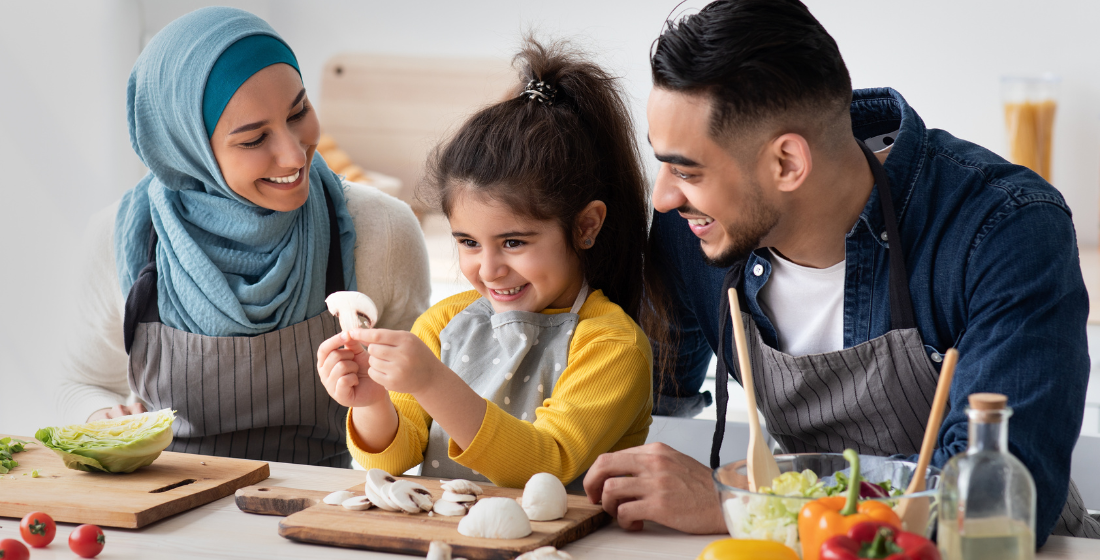Ouders en kind die samen koken en met eten bezig zijn