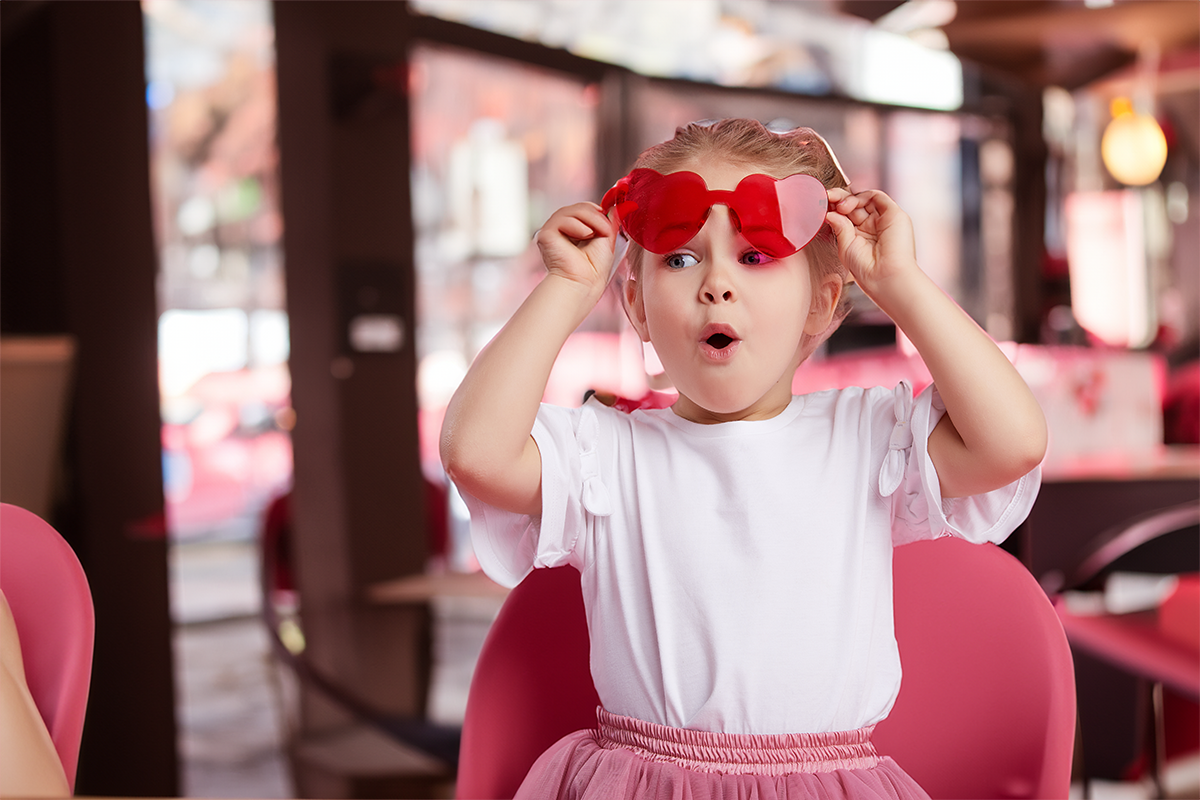 Kind met rode hartjes zonnebril op