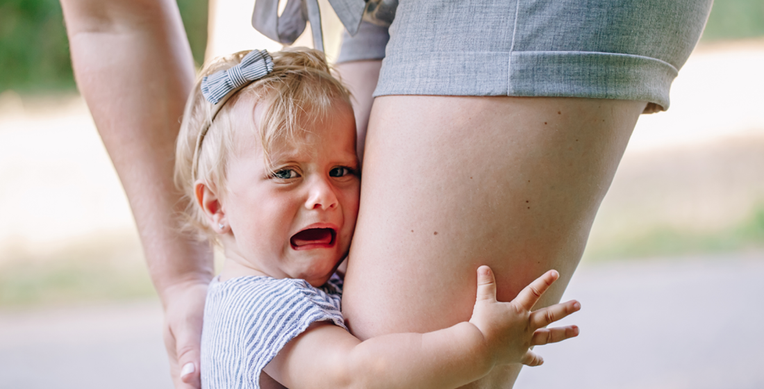 Meisje die been van ouder vastpakt en huilt