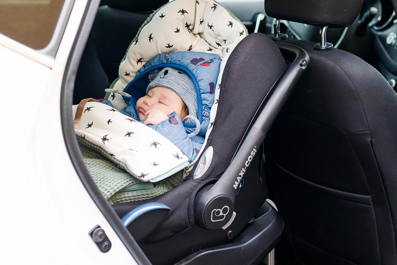 Baby aan het slapen in een babystoeltje in de auto
