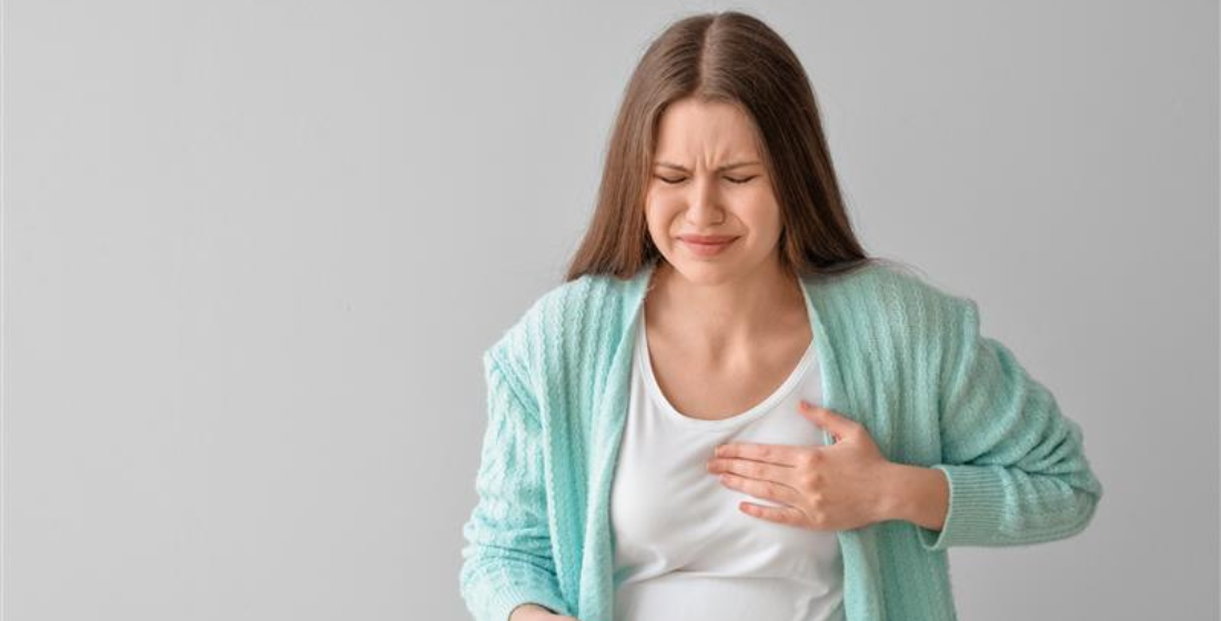 Vrouw die naar haar borst grijpt door een borstontsteking