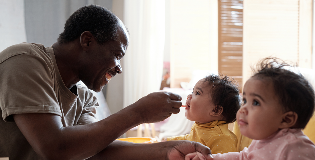 Vader die zijn tweeling eten geeft