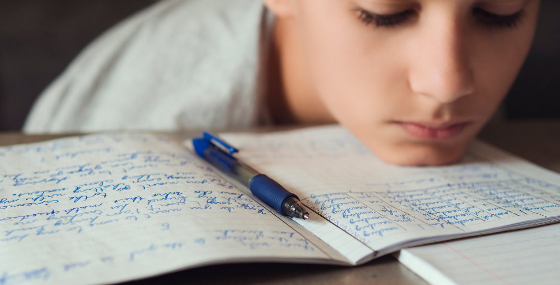 Kind kijkt uitgeput naar schrift met zinnen erin geschreven