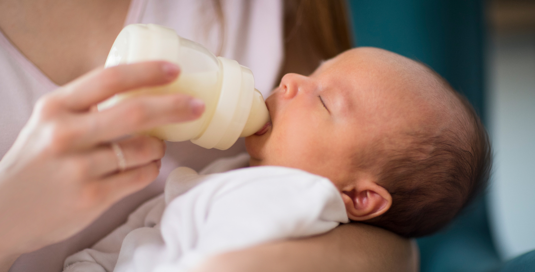 Baby die een flesje voeding krijgt