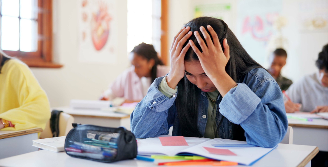 Meisje met haar handen in haar haar tijdens les in de klas