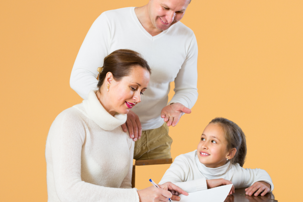 Ouders en dochter schrijven samen in schrift