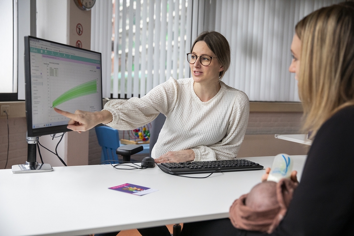 CJg-professional die met ouder naar groeicurve kijkt