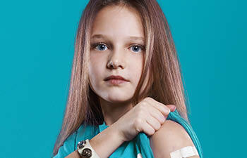 Meisje is net gevaccineerd en laat pleister op arm zien