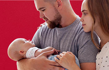 Vader en moeder kijken samen naar baby