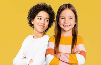 Twee kinderen met armen over elkaar lachend