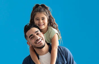 Vader heeft dochter op zijn rug en ze lachen