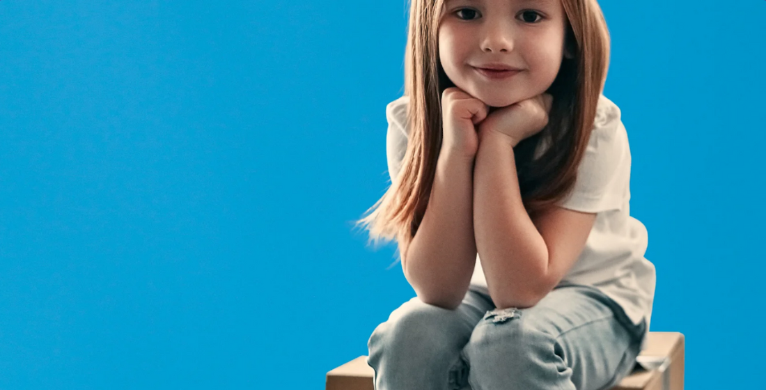 Meisje die op een verhuisdoos zit