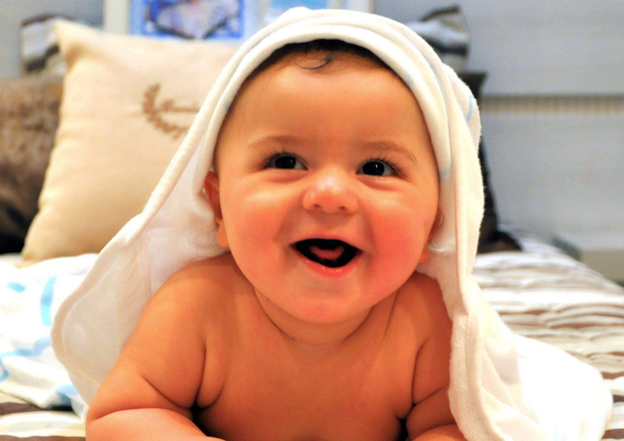 Baby met badcape om ligt op de buik