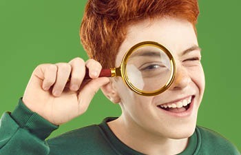 Tiener jongen kijkt door vergrootglas