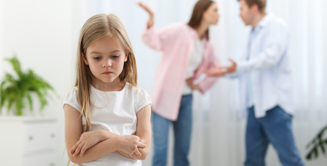 Verdrietig meisje en ouders die met elkaar ruziemaken.