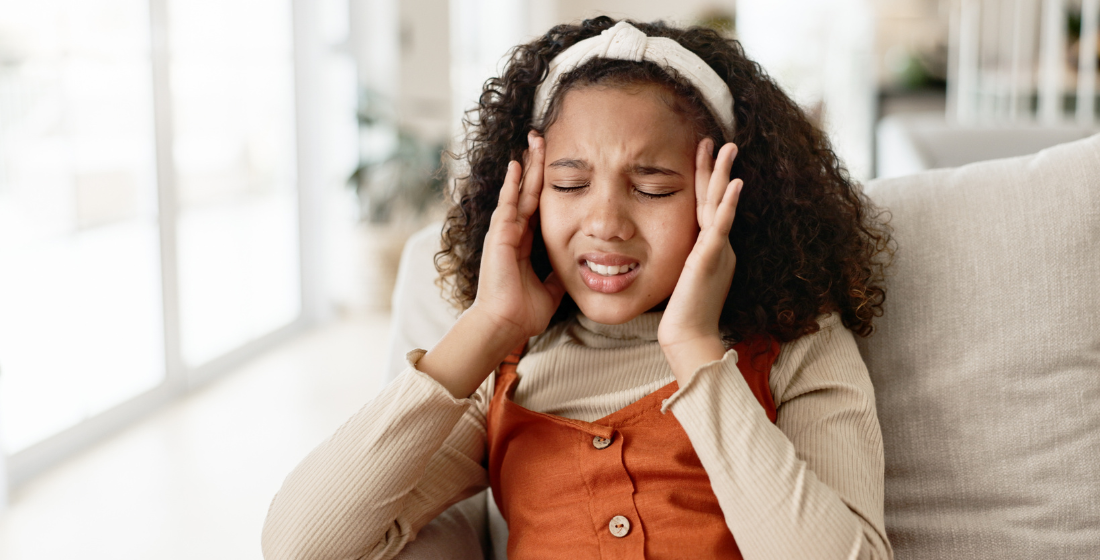 Meisje met hoofdpijn en haar hoofd vastpakt